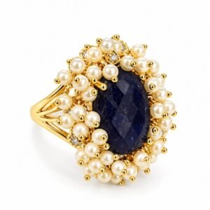 Anillo dorado con centro ovalado oscuro y detalles perlados